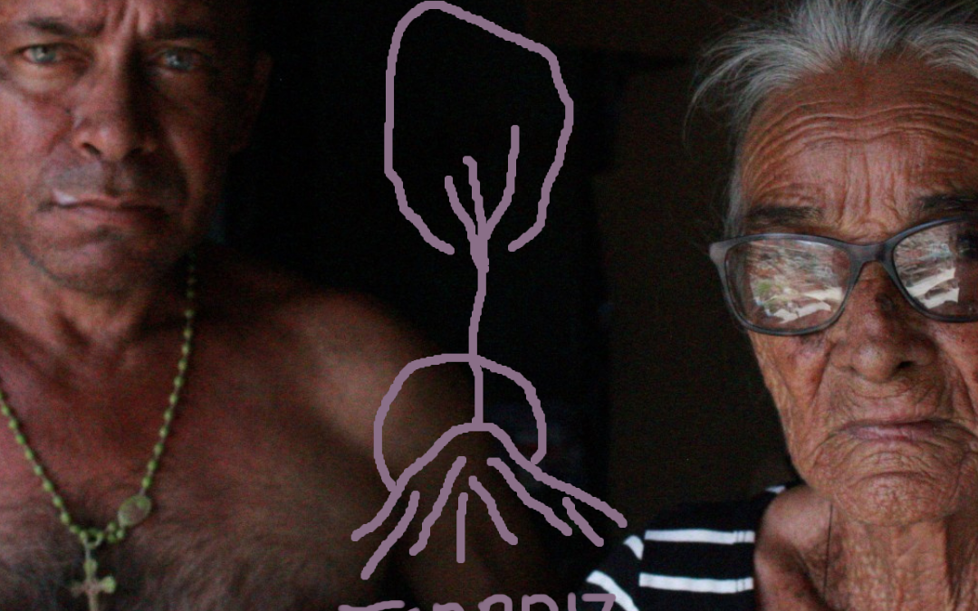 Foto em que aprece dois senhores, um homem e uma mulher. No centro, há um desenho que remete a raízes e arvores, em traço simples, e abaixo dele lê-se: Terraiz.