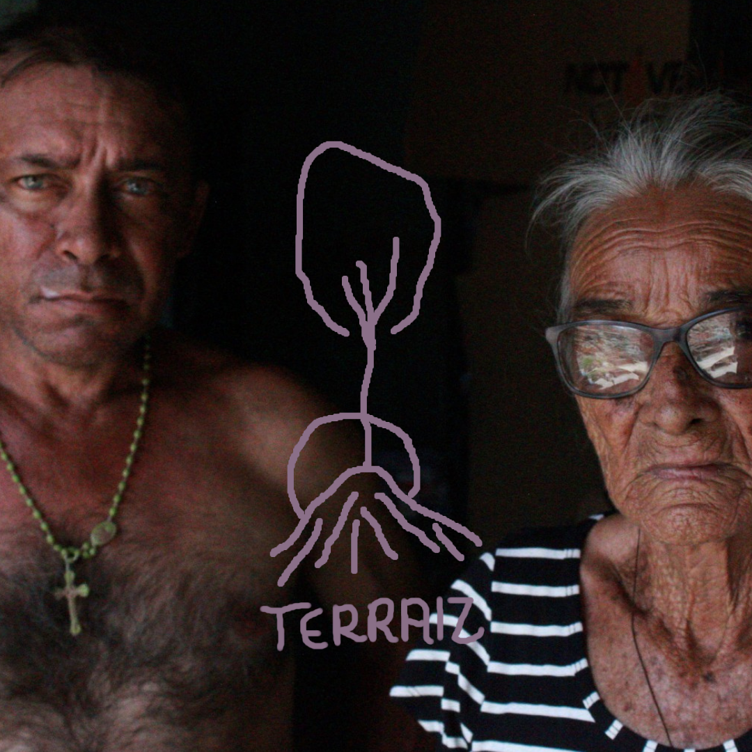 Foto em que aprece dois senhores, um homem e uma mulher. No centro, há um desenho que remete a raízes e arvores, em traço simples, e abaixo dele lê-se: Terraiz.