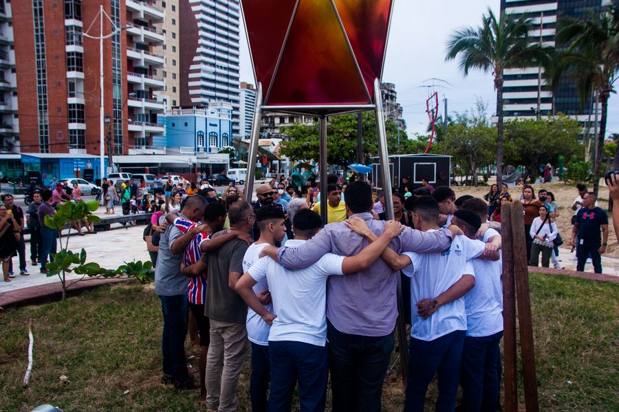 Várias pessoas abraçam o coração