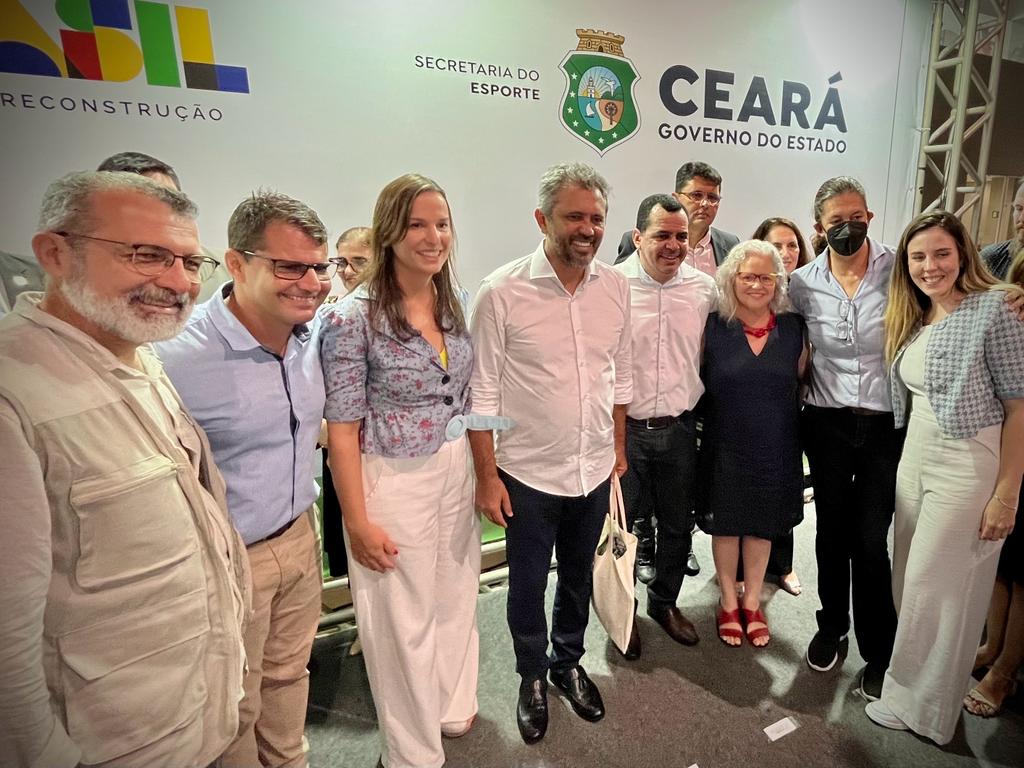 As autoridades reunidas no Centro de Formação Olímpica posam para a foto, com roupas de cores variadas. 