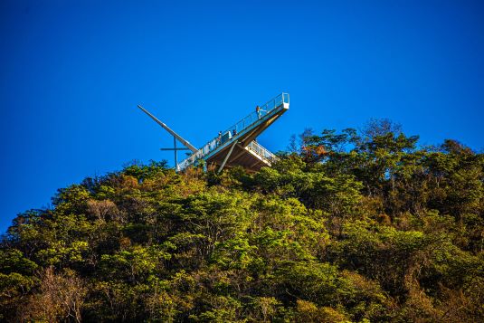 Uma grande área verde em altitude conta com uma esatrutura metálica em seu topo para ser um mirante.