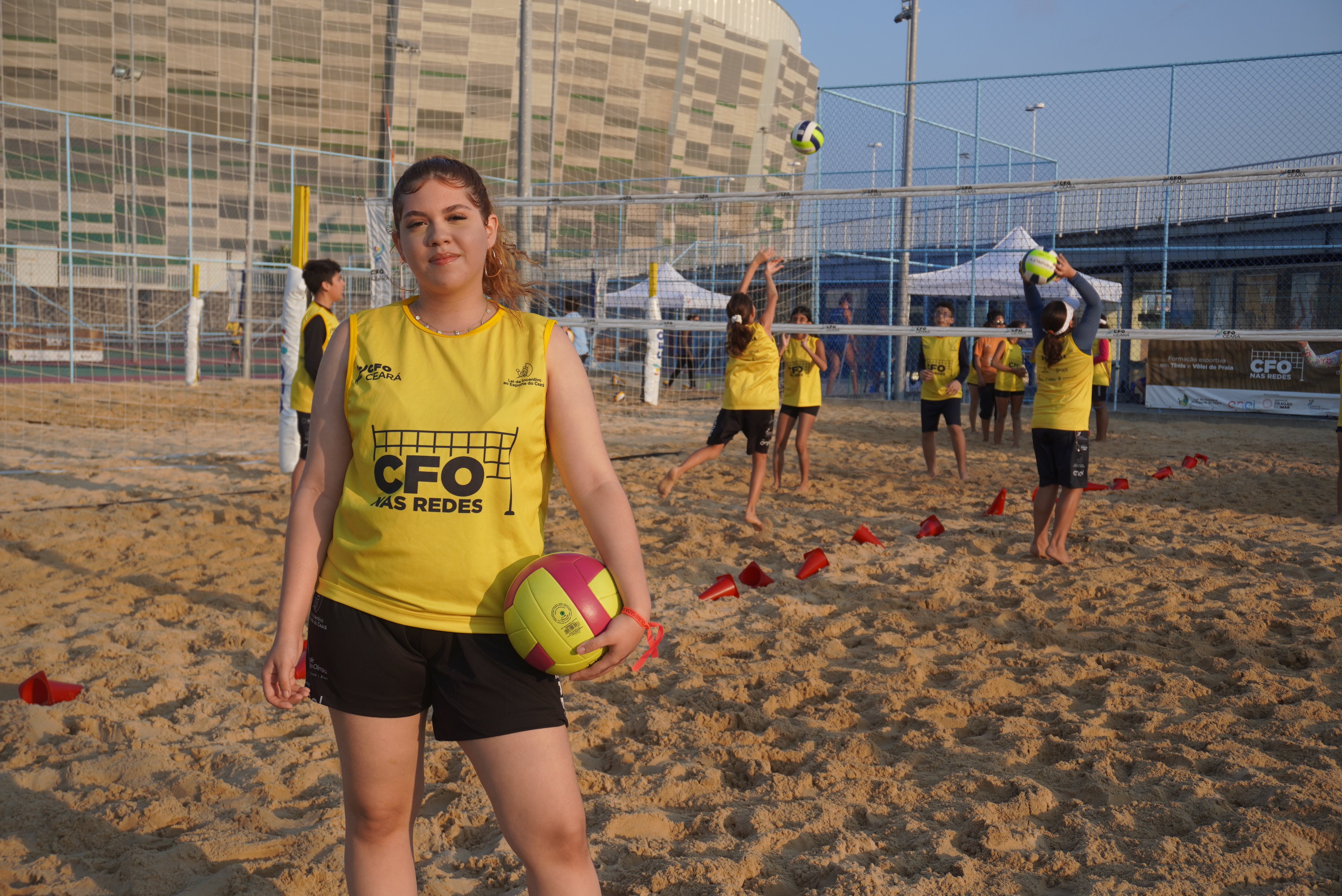 Jovem atleta segura uma bola de vôlei de praia durante treino do projeto 'CFO nas Redes', realizado nas quadras de areia do Centro de Formação Olímpica, em Fortaleza.